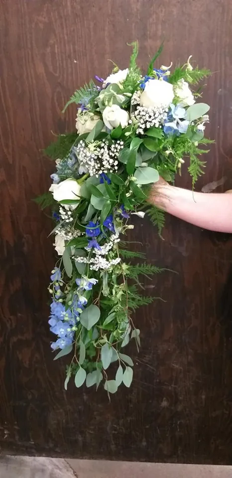 Droppformad brudbukett med blå och vita blommor