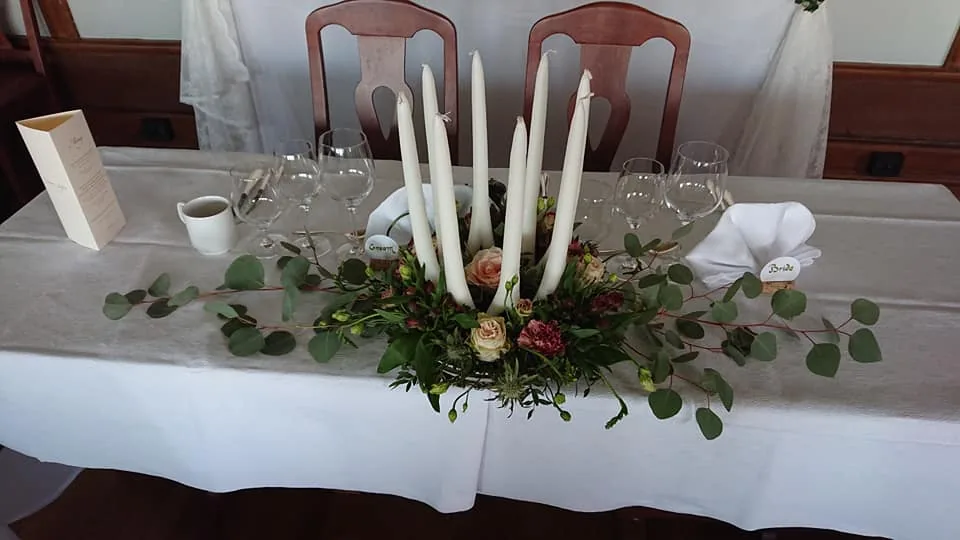 Bordsdekoration med ljus och grönt på dukat bord