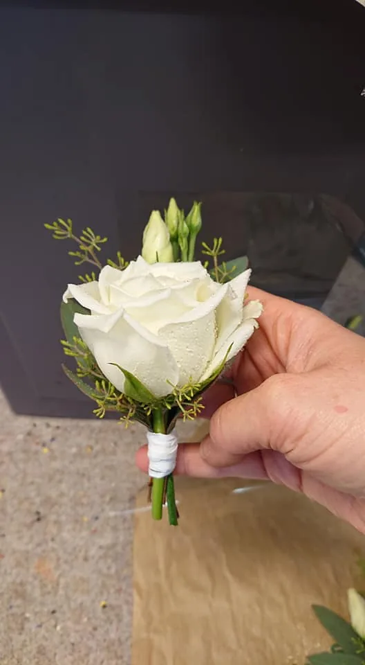 Corsage med vit ros i handen