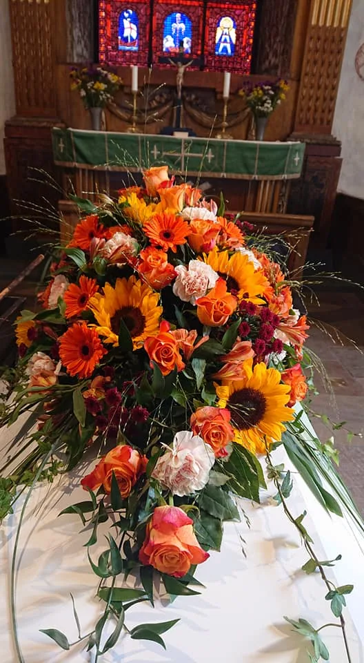 Kistdekoration med orange gerbera och liljor